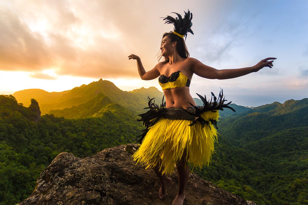 A Cook Islands dancer performing on a mountain ridge