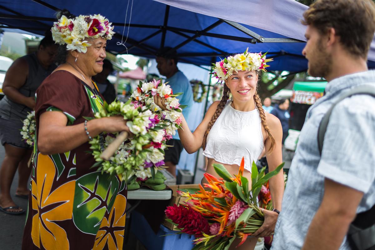 A local vendor sharing flowers with visitors at a market